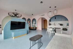 a kitchen with pink and blue cabinets and a table at Deo Plaza Basen & Sauna by Grand Apartments in Gdańsk +27 photos