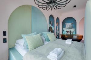 a bedroom with a large bed with a cat on it at Deo Plaza Basen & Sauna by Grand Apartments in Gdańsk