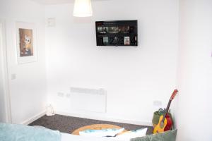 um quarto com uma parede branca com uma guitarra no chão em Quaint City Centre Residence em Liverpool