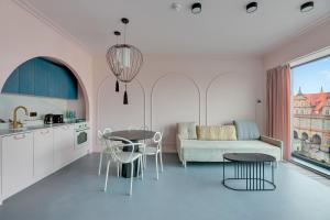 a kitchen and living room with a couch and a table at Deo Plaza Basen & Sauna by Grand Apartments in Gdańsk