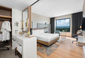 sypialnia z łóżkiem, umywalką i lustrem w obiekcie Holiday Inn & Suites Rayong City Centre, an IHG Hotel w mieście Rayong