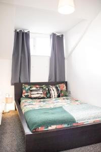 uma cama num quarto com uma janela em Quaint City Centre Residence em Liverpool