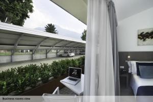 a bedroom with a laptop computer on a desk next to a road at Seven Park Hotel Lake Como - Adults Only in Colico