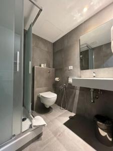 een badkamer met een toilet, een wastafel en een spiegel bij Hotel Garda in Rome