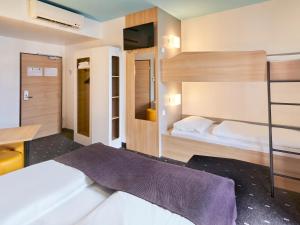 - une chambre avec des lits superposés et un bureau dans l'établissement B&B Hotel Mainz-Hbf, à Mayence