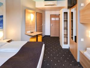 Cette chambre comprend un lit et un bureau. dans l'établissement B&B Hotel Mainz-Hbf, à Mayence