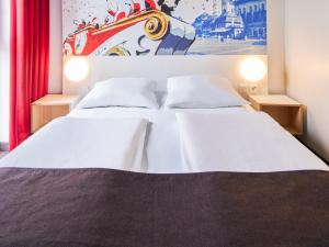 1 dormitorio con 2 camas y un cuadro en la pared en B&B Hotel Mainz-Hbf, en Mainz