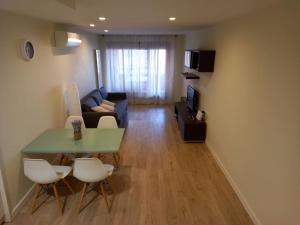 Una sala de estar con una mesa y sillas y un sofá. en El Ritual Apartamento, en Tudela