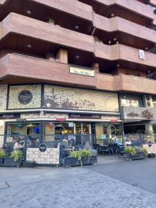 una tienda frente a un edificio con mesas y sillas en El Ritual Apartamento, en Tudela
