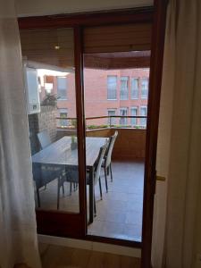 a glass door leading to a balcony with a table and chairs at El Ritual Apartamento in Tudela