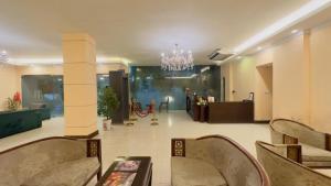 uma ampla sala de estar com cadeiras e um lustre em Hotel Fountain Luxury In Comfort em Daca