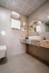 ein Bad mit einem Waschbecken und einem WC in der Unterkunft Lara Garden Hotel in Lara