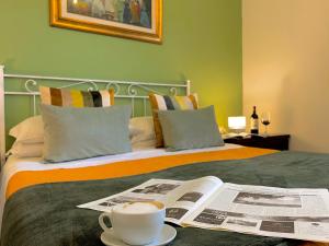 a bed with a newspaper and a cup of coffee on it at Resort Il Casale Bolgherese - by Bolgheri Holiday in Bolgheri