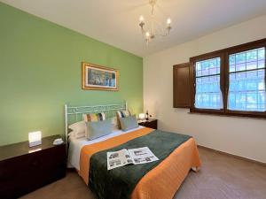 sypialnia z łóżkiem i żyrandolem w obiekcie Resort Il Casale Bolgherese - by Bolgheri Holiday w mieście Bolgheri