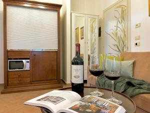 stół z dwoma kieliszkami wina i książką w obiekcie Resort Il Casale Bolgherese - by Bolgheri Holiday w mieście Bolgheri
