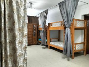 a room with two bunk beds and a curtain at Executive Becholars Hostel in Dubai