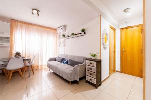 een woonkamer met een bank en een tafel bij Apartamento en el centro a un minuto de la playa in Benidorm
