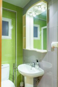 een badkamer met een wastafel, een toilet en een spiegel bij Apartamento en el centro a un minuto de la playa in Benidorm