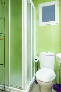 een groene badkamer met een toilet en een douche bij Apartamento en el centro a un minuto de la playa in Benidorm