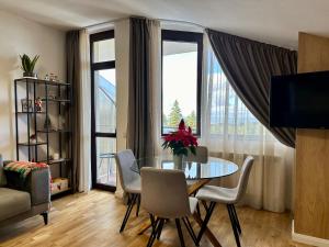 a living room with a table and chairs and a window at Sana Ski apartment 702 in Flora, Borovets in Borovets