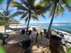 una mesa y sillas en una playa con palmeras en SEASHORE Resort & Villa, en Talpe