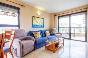 a living room with a blue couch and a table at ESPACIO 3 - Primera Línea de Playa in Cullera