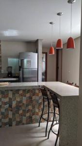 a kitchen with two chairs sitting at a counter at Casa de praia in Guarapari