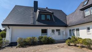ヴェスターラントにあるFerienwohnung Nordsternの黒屋根白屋根