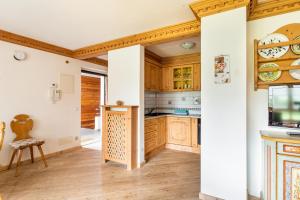 a kitchen with wooden cabinets and wooden floors at Aurturist Appartement 185 in San Vigilio Di Marebbe