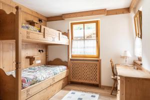 a bedroom with bunk beds and a window at Aurturist Appartement 185 in San Vigilio Di Marebbe