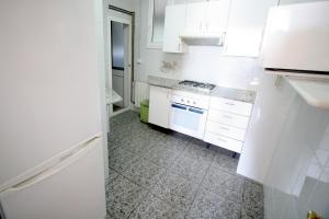 a kitchen with white cabinets and a white refrigerator at Near Maresme Forum Apartment in Barcelona