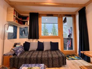 een woonkamer met een bank voor een raam bij Le Petit Cham in Chamonix-Mont-Blanc