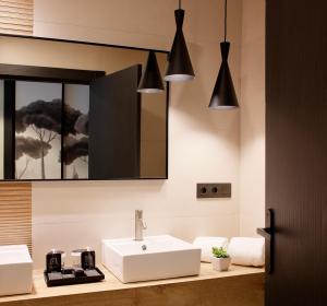 a bathroom with a white sink and a mirror at Nuvō Hotel Boutique in Oviedo