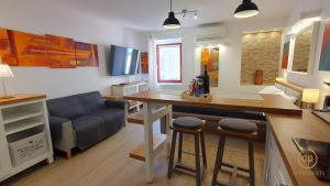 a living room with a kitchen with a table and a couch at Studio EMA - Tartini Square in Piran