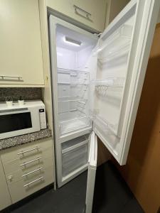 einen Kühlschrank mit offener Tür in der Küche in der Unterkunft FIRA Gran Vía 2 - Private Rooms in a Shared Apartment - Habitaciones Privadas en Apartamento Compartido in Hospitalet de Llobregat