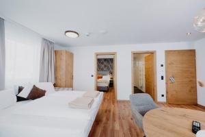 a white bedroom with a bed and a table at Hotel Brückenwirt in Altenmarkt im Pongau