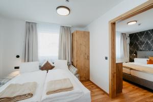 ein Schlafzimmer mit einem großen weißen Bett und einem Fenster in der Unterkunft Hotel Brückenwirt in Altenmarkt im Pongau