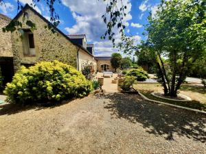 a garden in front of a stone house at O Gîte Bleu 