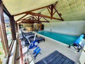 an indoor swimming pool with chairs and a moped and a swimming pool at O Gîte Bleu 