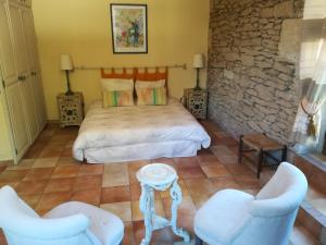 a bedroom with a bed and two chairs at La Camiranaise in Camiran