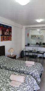 Pokój z 2 łóżkami i stołem oraz kuchnią w obiekcie MONO BAMBU w mieście Salta