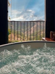 a jacuzzi tub in a room with a view at Love, made in xisto in Piódão