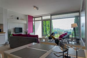 soggiorno con divano e tavolo con bicchieri da vino di VacationClub – Bukowa 17 Apartament B.2 a Wisła