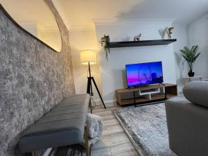 sala de estar con sofá y TV de pantalla plana en Modern & Stylish Haven In Heart of London, en Londres