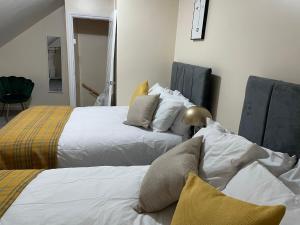 a bedroom with two beds with pillows at St James House - Sleeps 8! in Leeds