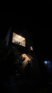 a building with a lit up window in the dark at Supritha Homestay Hampi in Hampi