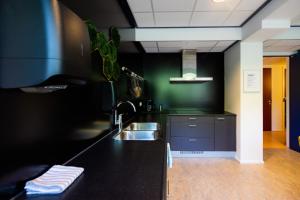 a kitchen with a sink and a black counter at Rooms25 in Amsterdam