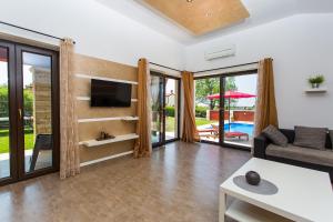 ein Wohnzimmer mit einem Sofa und einem TV in der Unterkunft Activity villa Marula with outdoor pool in Buje in Gamboci
