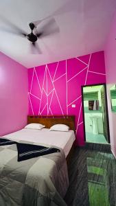 a pink room with two beds and a mirror at Supritha Homestay Hampi in Hampi