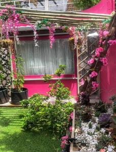 a pink house with flowers on the side of it at Residence William French in Simonʼs Town